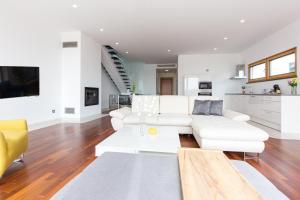 a living room with white furniture and a kitchen at Villa Superior Two in Crikvenica