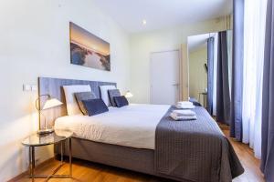 a bedroom with a large bed and a night stand at Hotel Mare Liberum in Egmond aan Zee