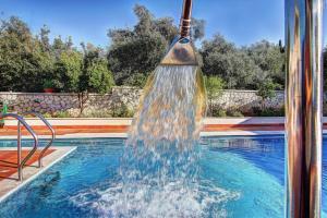 a water fountain in the middle of a swimming pool at The Love Villa in Kassiopi
