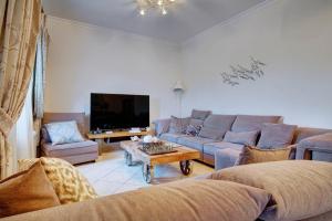 a living room with a couch and a tv at The Love Villa in Kassiopi