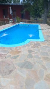 una pequeña piscina azul con un patio de piedra en La Casa del Árbol in 