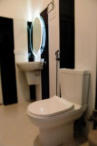 a bathroom with a white toilet and a sink at Dinuda Resort in Kalpitiya