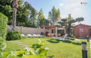 un patio con tumbonas y una casa en Hotel Piñeiro 2 Estrellas Superior en A Lanzada