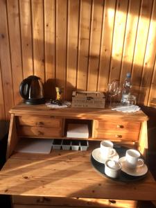 una mesa de madera con tazas y platillos. en Iowa Ranch - Agroturystyka Antoniew, 