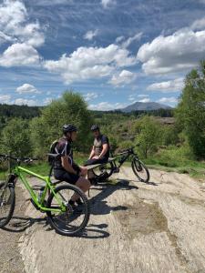 two people sitting next to their bikes on a dirt road at Riverside apartment in Betws-y-coed