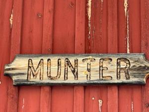 a sign on the side of a red wall at Homestay in picturesque village 