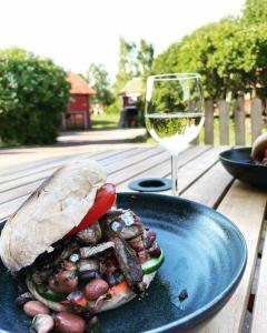 a plate with a sandwich and a glass of wine at Homestay in picturesque village 