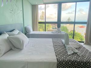 - une chambre avec 2 lits et une grande fenêtre dans l'établissement Pousada Amada Terra, à Porto de Galinhas
