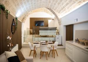 een keuken en een woonkamer met een tafel en stoelen bij LC Luxury Apartment in Bari