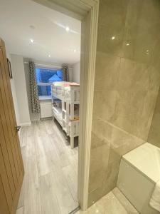 a bathroom with a walk in shower and a bedroom at 2a Seymour Road in Hackbridge