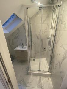 a bathroom with a shower and a sink at 2a Seymour Road in Hackbridge