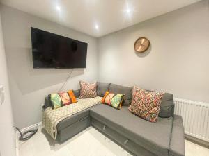 a living room with a couch and a flat screen tv at 2a Seymour Road in Hackbridge