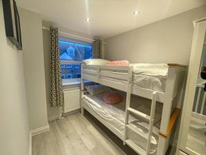 a small room with a bunk bed with a window at 2a Seymour Road in Hackbridge