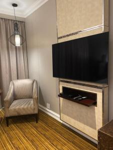 uma sala de estar com uma televisão e uma cadeira em InterContinental Johannesburg OR Tambo Airport Hotel, an IHG Hotel em Kempton Park