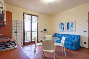 uma sala de estar com uma mesa e um sofá azul em Pool - Marge Apartment - by Host4U em Padenghe sul Garda