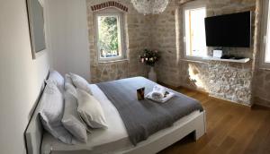 a bedroom with a bed with a tv on the wall at La BellaSu House in house in Sutivan