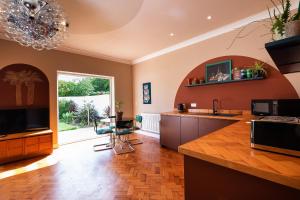 a large kitchen with a sink and a large window at Art Deco Coastal Apartment with Private Garden in Broadstairs