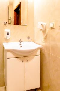 uma casa de banho com um lavatório e um espelho em Al-Dom Apartamenty Awangardia 434 em Kolobrzeg