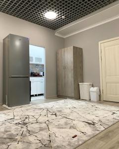an empty room with a refrigerator and a kitchen at Magistral in Bishkek