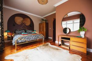 een slaapkamer met een bed en een spiegel bij Art Deco Coastal Apartment with Private Garden in Broadstairs