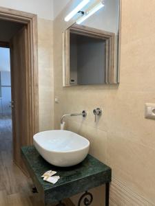 W łazience znajduje się biała umywalka i lustro. w obiekcie Casa vacanze Rosemary w mieście Nardò