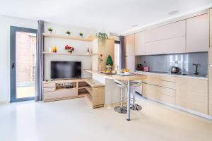 a kitchen with a table and a tv in it at CARTAGENAFLATS, Apartamentos Calle Mayor II, PREMIUM FLATS CITY CENTER in Cartagena
