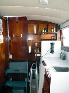 una pequeña cocina con armarios de madera y fregadero en PRECIOSO BARCO EN EL PUERTO DE BADALONA, en Badalona