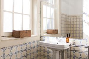 ein Bad mit einem Waschbecken und einem Spiegel in der Unterkunft Alameda Suites - River Guest House in Porto