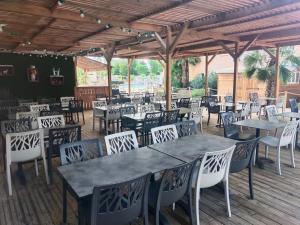 Un restaurante con mesas y sillas en una terraza. en camping les sables du midi, en Sérignan