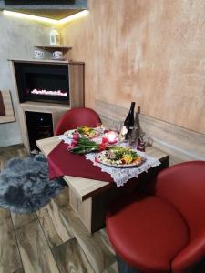 格涅茲諾的住宿－Klinkierowa Komnata，一张桌子,上面放着一盘食物和一瓶葡萄酒