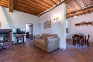 a living room with a couch and a television at Poggio Vitignano Charming Cottage With Pool and Parking in Pianella