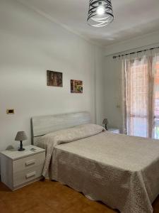 1 dormitorio blanco con 2 camas y ventana en Villa Marina, en Torvaianica
