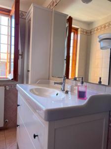 y baño con lavabo blanco y espejo. en Villa Marina, en Torvaianica