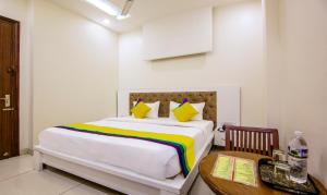 a bedroom with a large bed with a table and a desk at Itsy By Treebo - GM Residency in Chandīgarh
