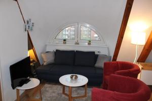- un salon avec un canapé bleu et deux fauteuils rouges dans l'établissement AD2-33 - Appartement Typ D, à Dorum Neufeld