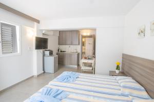 a bedroom with a large bed and a kitchen at Ayia Napa Holiday Apartment Ss1 in Ayia Napa