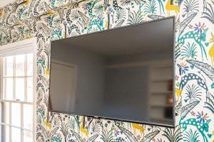 4BR/3BA Luxurious Decatur Home w/ Patio & Backyard في ديكاتور: مرآة على الحائط مع ورق جدران