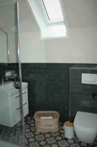 a bathroom with a toilet and a sink and a skylight at GASTHAUS Porzelt -Ferien im Weingut - Wohnung 2 in Klingenmünster