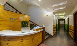 a lobby with a wooden accent wall and a counter at Itsy By Treebo - GM Residency in Chandīgarh