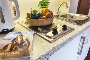 una encimera de cocina con un bol de fruta y una revista en Gästehaus Röll - Studio 4 en Norderney