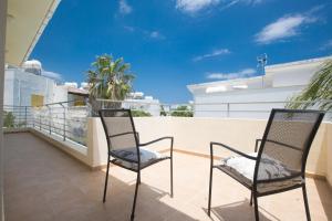 zwei Stühle auf dem Balkon eines Hauses in der Unterkunft Protaras Delfini Villa Dv4 in Protaras