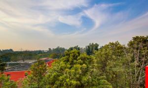 チャンディーガルにあるItsy Hotels GM Residencyの赤い建物と木々、そして青い空