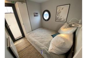 a small bedroom with a bed and a window at Hausboot Fjord Capella - Solarboot in Barth in Barth