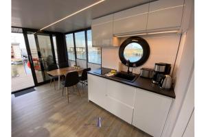 a kitchen and dining room with a table and a mirror at Hausboot Fjord Capella - Solarboot in Barth in Barth