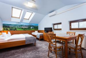 a hotel room with two beds and a desk at Hotel Jelínkova vila in Velké Meziříčí