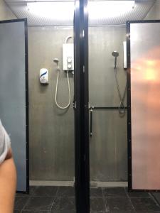a bathroom stall with a shower and a phone at 24 Seven B&B Mamasan in Kuching