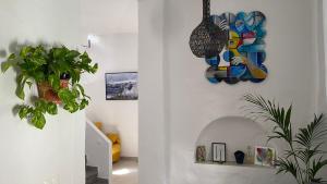 uma sala de estar com plantas e um quadro na parede em Casa Palma em Cómpeta