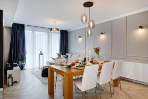 una sala da pranzo con tavolo e sedie bianche di Apartament Heaven a Katowice