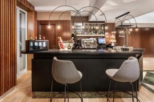 a bar in a hotel room with two chairs at Catalonia Goya in Madrid