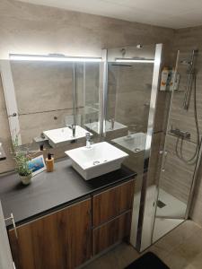 uma casa de banho com um lavatório branco e um chuveiro em Cozy apartment with pool close to beach & nature em L'Estartit